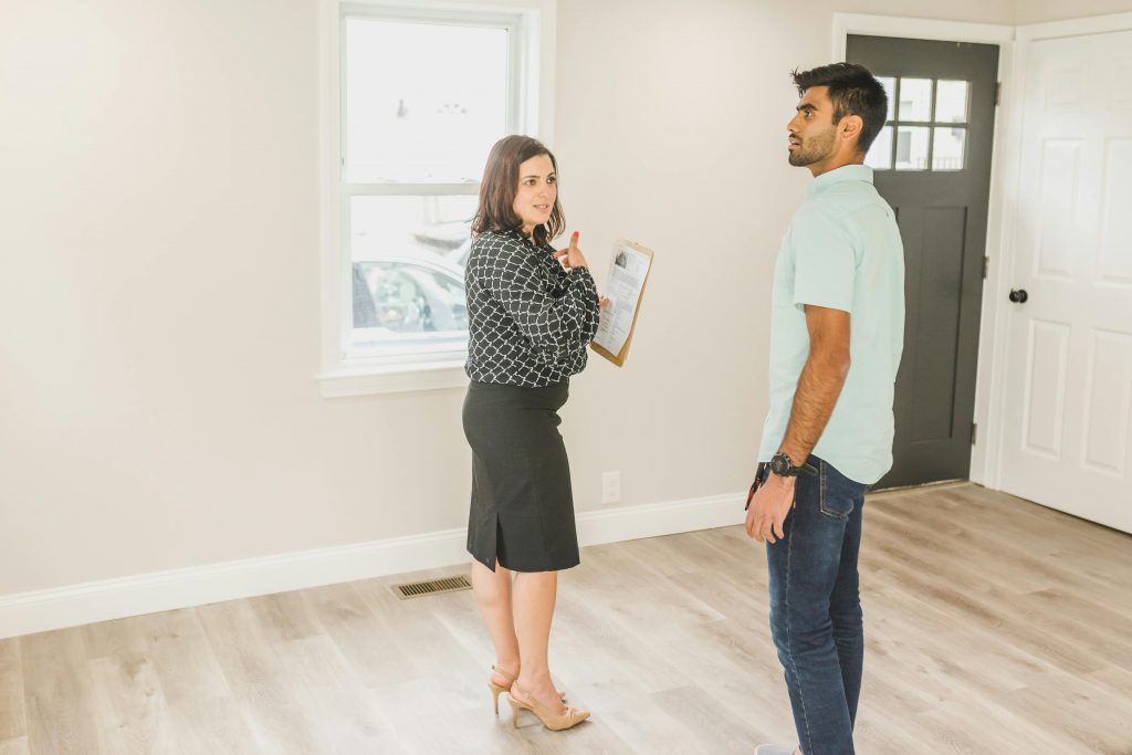 Real estate agent showing a modern home interior to a potential buyer.